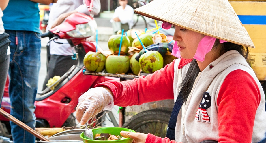 Vietnamese women street vendors wearing conical hats
