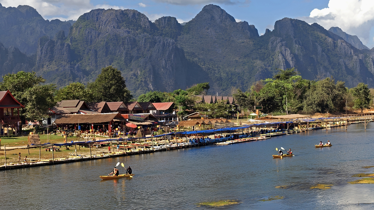 Kayaking down the Nam Song River between lush green cliffs