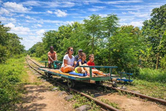 A family discovering the Bamboo Train in Battambang during a Northwest Cambodia itinerary with kids