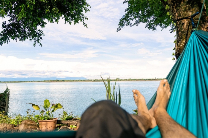 Souchitra Riverside Guesthouse with a view of the Mekong in a hammock