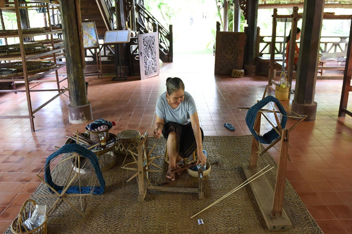 Explore traditional tie-dye and silk weaving indoors while the rain in Laos falls outside.