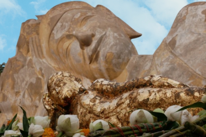 A miniature Reclining Buddha covered in gold leaves