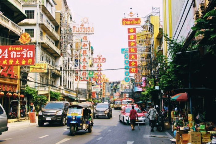 Colorful street signs line busy road in Bangkok