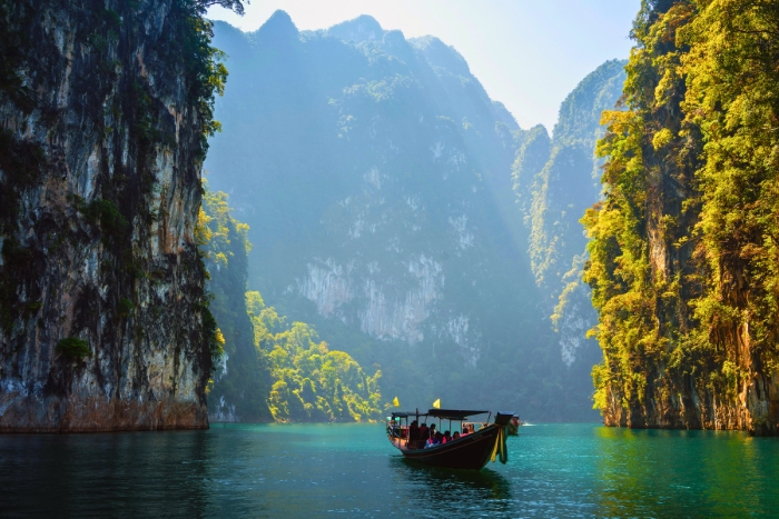 Limestone cliffs rise above emerald lake in Khao Sok