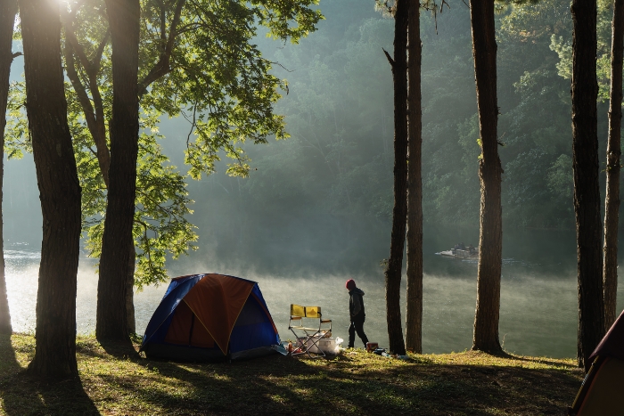 Camping in the middle of nature, on the mountain, and admiring the lake in the mist in the early morning