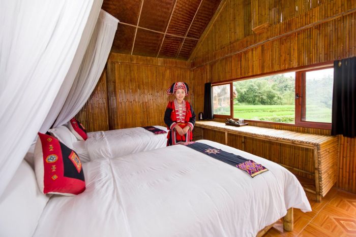 The rooms are decorated in shades of brown and red wood, offering a warm atmosphere reflective of the Dao ethnicity of Ha Giang