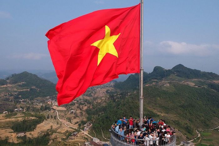 Admire the Vietnamese flag flying at Lung Cu Ha Giang