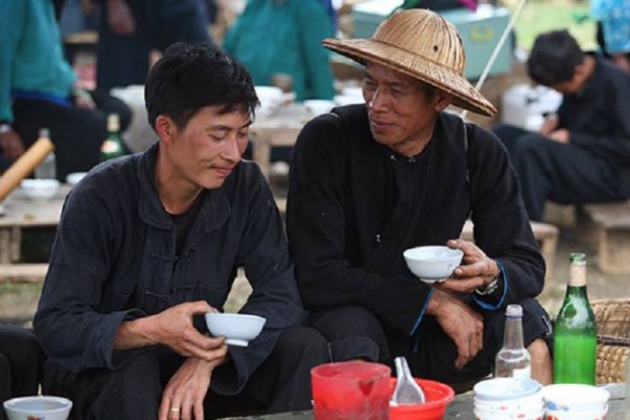 Men drinking corn alcohol at Quan Ba market