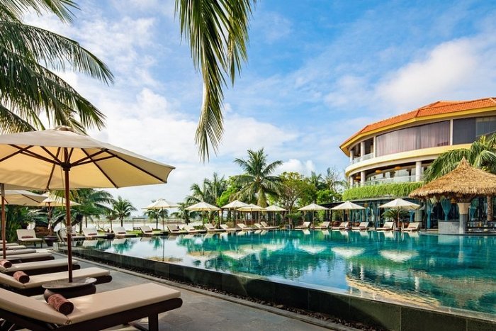 The infinity pool surrounded by lush greenery at Bel Marina Hoi An Resort