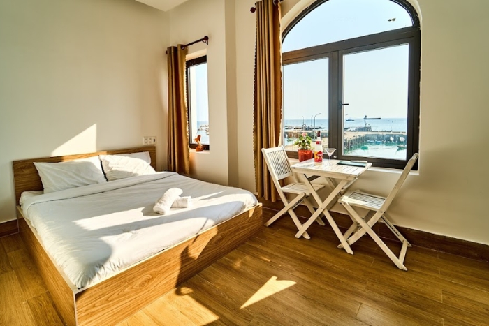 Room with a big window overlooking the street and sea
