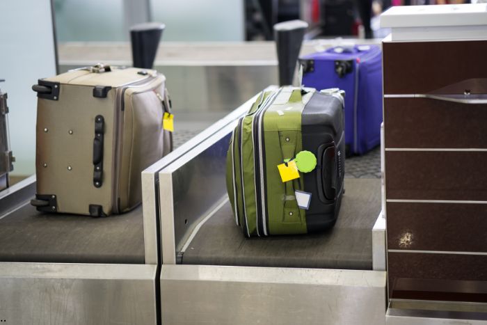 Checked luggage is dropped off at the check-in counter.