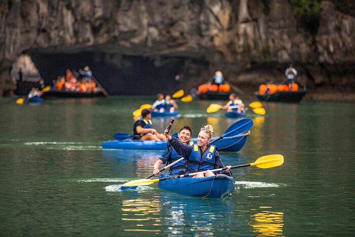 International tourists row boats to explore Ha Long Bay