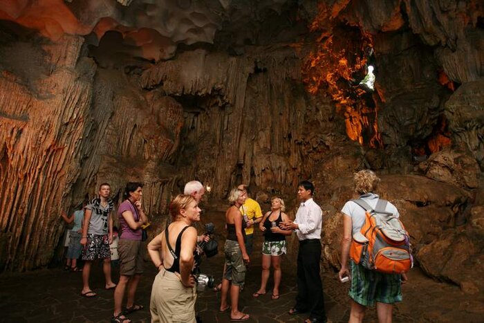 Tourists explore the Surprise cave in Ha Long Bay 