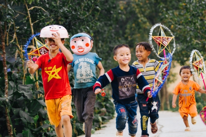 Children play with lanterns in street